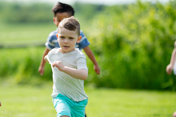 istock Young Boys Running Outdoors in Green Park, Active Play and Outdoor Fun 2243701290