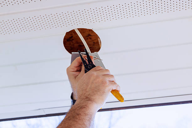 istock Worker installs ceiling light fixture in home during daylight hours in residential area 2243707725