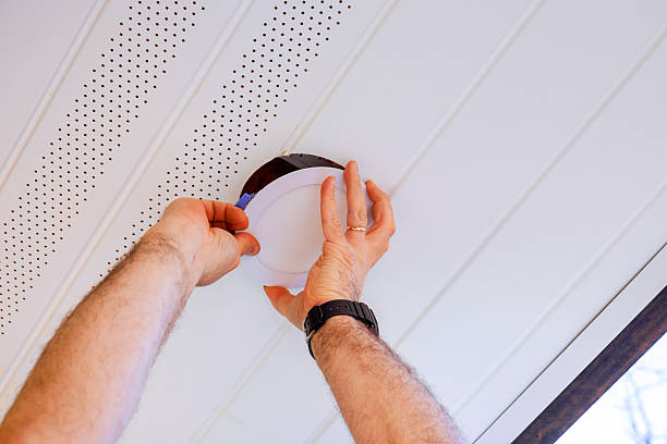 istock Hands installing round ceiling light fixture in modern home interior during works daytime 2243707726
