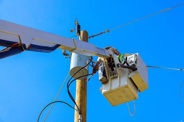 istock Workers performing maintenance on utility pole with clear blue sky overhead 2243707787