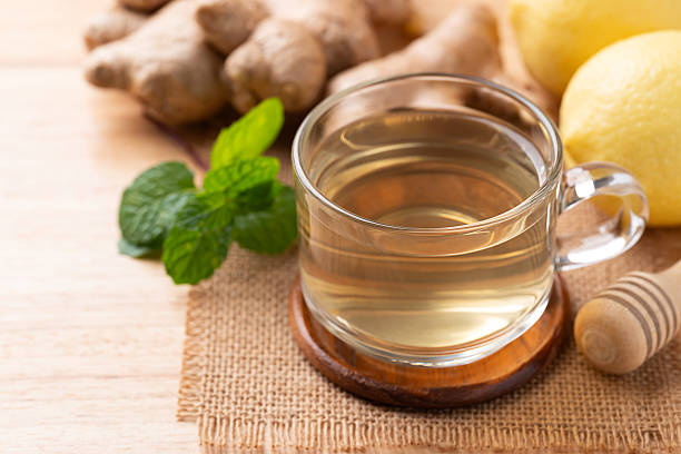 istock Lemon and ginger tea in cup glass on wooden background 2243709733