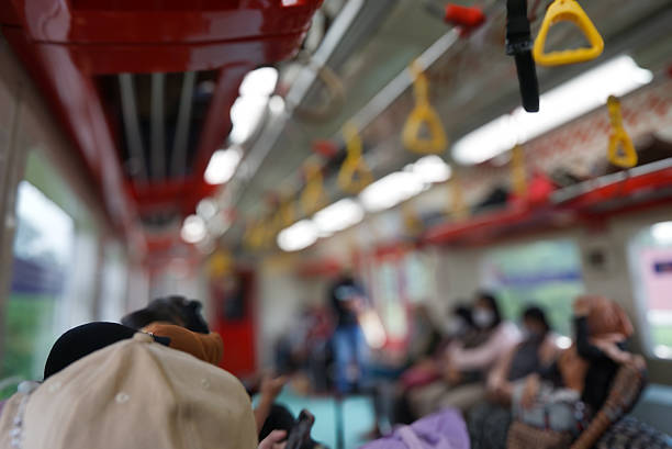 Urban commuter traveling by train. Passengers sitting inside a commuter train with a grab handle.