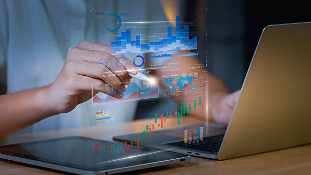 istock Business analyst using digital tablet and laptop with holographic data charts and financial analytics dashboard, representing big data visualization, fintech investment, and smart business strategy. 2243718447