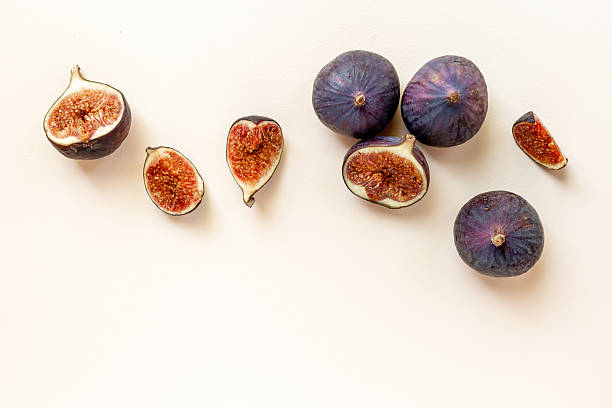 istock Purple ripe figs and slices top view on a stone background 2243718854