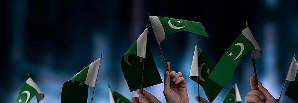 istock Pakistan flags in their hands on a blurred urban background 2243723832