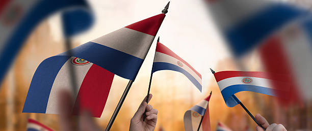 istock Paraguay flags in their hands on a blurred urban background 2243723983