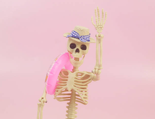 Skeleton with bright orange hat posed against black background.