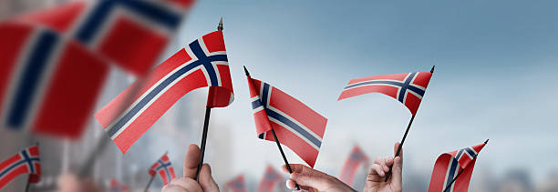 istock Norway flags in their hands on a blurred urban background 2243724102