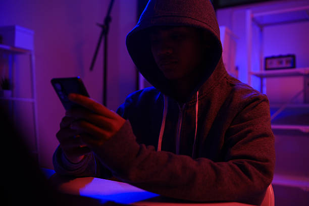 istock A mysterious hooded hacker working on a computer in a dark room. 2243725219