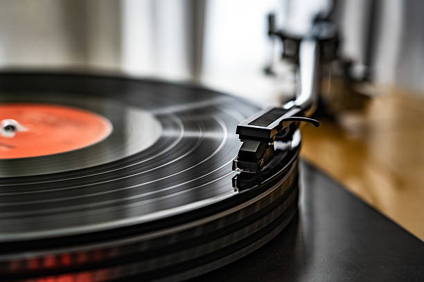 A close-up of a spinning vinyl record on a turntable, capturing the motion of grooves and the stylus. Classic analog music setup evokes nostalgia, creativity, and warm sound.