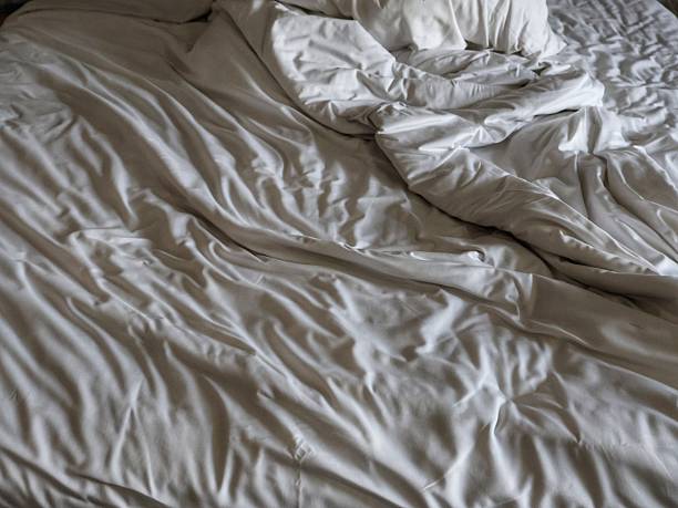 istock an unmade bed with wrinkled, messy white bed sheets 2243727092