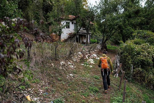 Man with backpack hiking alone through old abandoned village