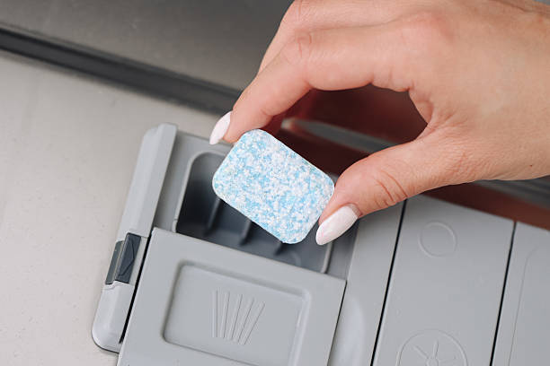 istock Female hand holding blue dishwasher tablet above detergent compartment. Household cleaning concept symbolizing hygiene, modern lifestyle, and convenience. 2243727190