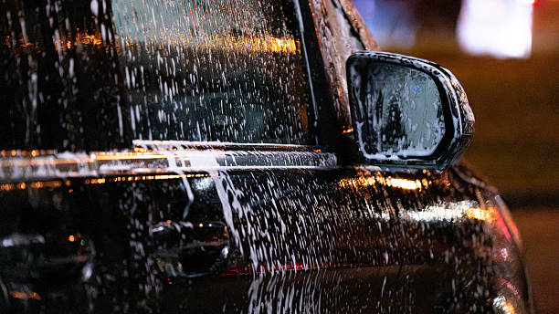 istock Black car being washed at night with soap foam 2243727452
