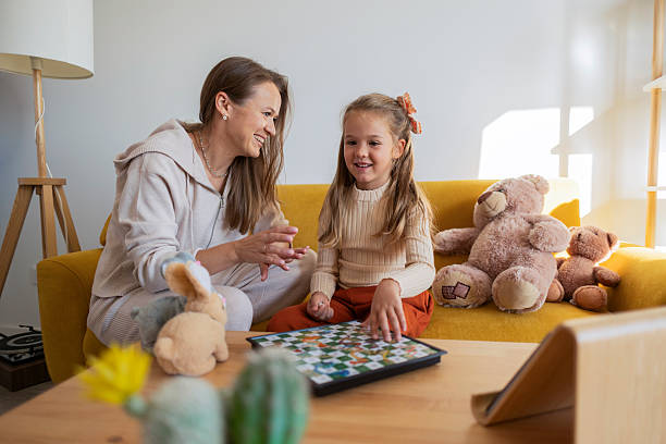 istock Mother and daughter playing board game at home 2243729181