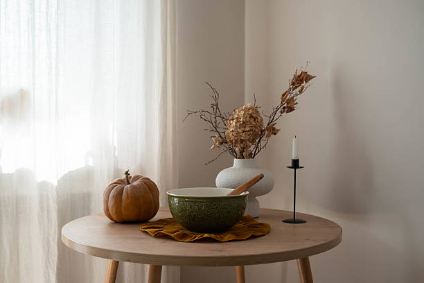 istock fall themed decorative arrangement, rustic autumn table scene with pumpkin, green bowl, vase with dry autumn branches calming ambiance and soft light 2243730885