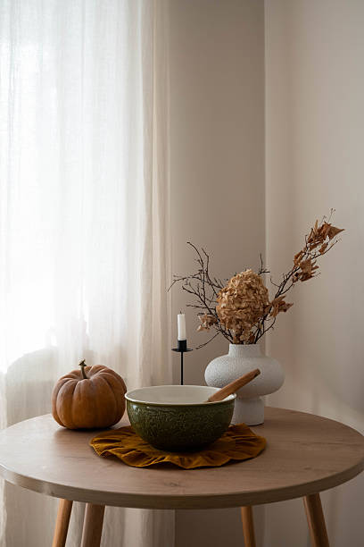 istock fall themed decorative arrangement, rustic autumn table scene with pumpkin, green bowl, vase with dry autumn branches calming ambiance and soft light 2243730943