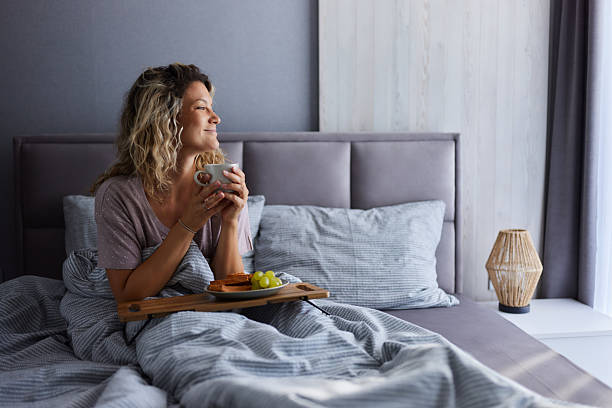 istock Smiling woman having coffee during breakfast in a bed. 2243733139