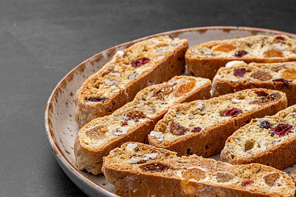 istock Italian Almond Biscotti biscuits in a rustic home made pottery bowl. Studded with almonds and cranberries, these twice-baked treats are aromatic and inviting. Ideal. 2243734622