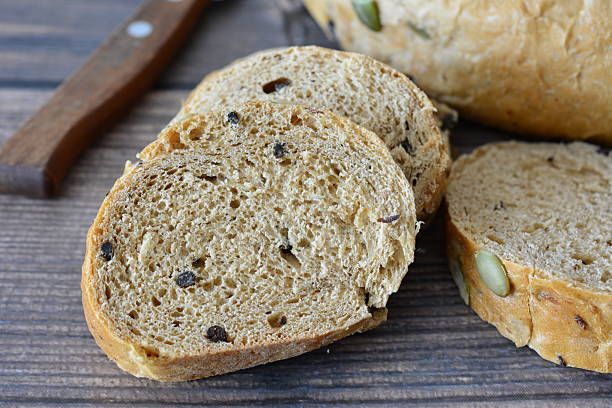 istock Sliced Whole Wheat Bread with Pumpkin Seeds on a Wooden Table macro 2243734744