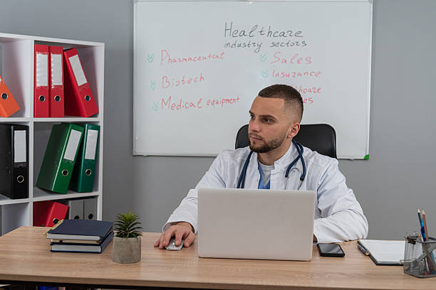 istock doctor man sitting at the desk using laptop computer for webinar training ar medical themes 2243735790