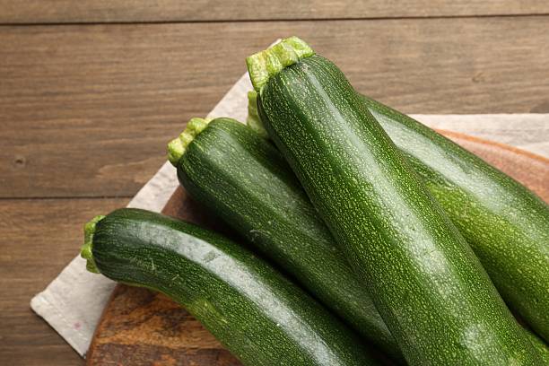 istock Fresh ripe zucchinis on wooden table, top view. Space for text 2243736023