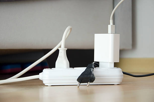 istock Power Strip with Multiple Plugs and Charger on Wooden Floor 2243736822