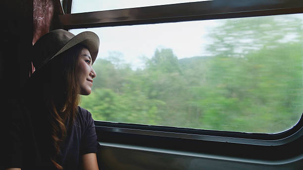 istock A female train passenger looking at the trees and forest views outside window 2243736950