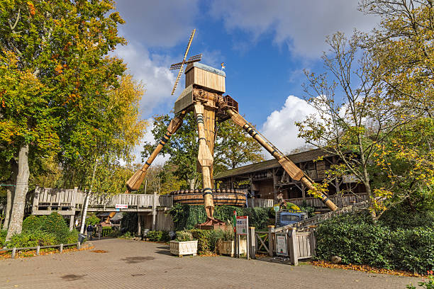 The imposing Mad Mill ride, a giant wooden structure resembling a cross between a windmill and a walking machine, looms over a path at Duinrell park. Wassenaar, Netherlands. 24 October 2025.