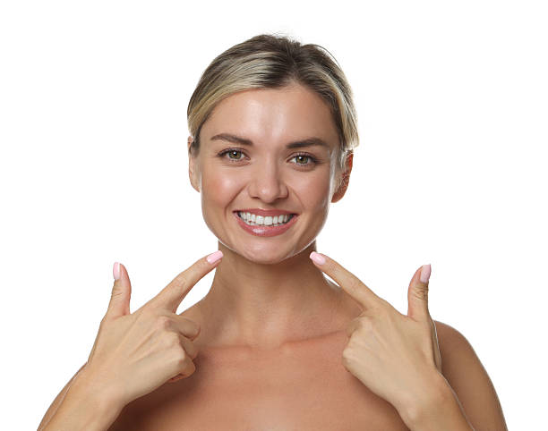 istock Woman pointing at her healthy teeth on white background 2243739341