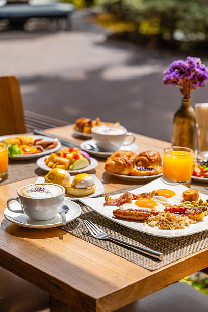 istock Outdoor breakfast setting with coffee, juice, eggs, bacon on wooden 2243742596