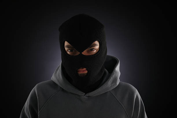 istock Criminal man in mask on dark background 2243743568