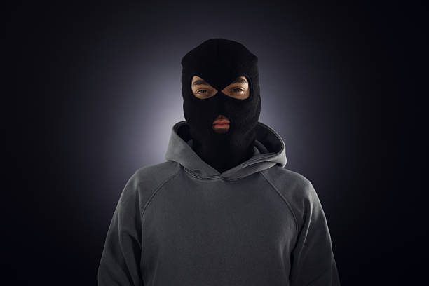 istock Criminal man in mask on dark background 2243743661