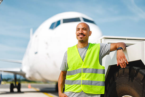 istock Joyful Hispanic Tug Operator Standing Confidently Near Aircraft on Bright Sunny Day 2243743878