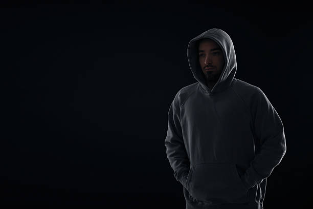 istock Criminal man in hood on dark background. Space for text 2243743906