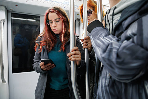 istock Beautiful young woman riding subway train, using smart phone 2243744114