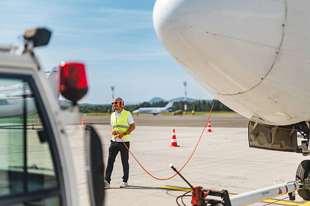 istock Content Hispanic Male Technician Guiding Aircraft with Precision on Runway 2243744171