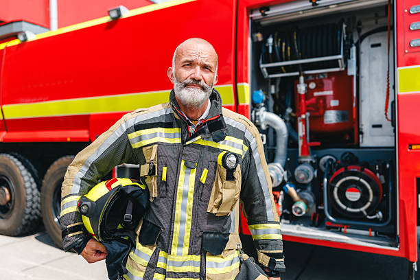 istock Determined Mature Caucasian Firefighter Standing Proudly Near Red Fire Engine in Sunlight 2243744442
