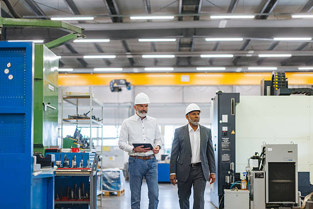 istock Confident Mature Engineer and Hispanic Manager Walking Through Industrial Factory 2243745408
