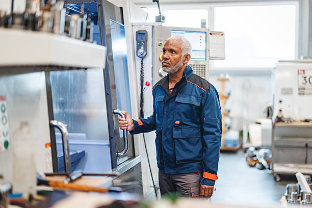 istock Concentrated Mature Hispanic Technician Engaging with CNC Equipment in Bright Industrial Setting 2243745492