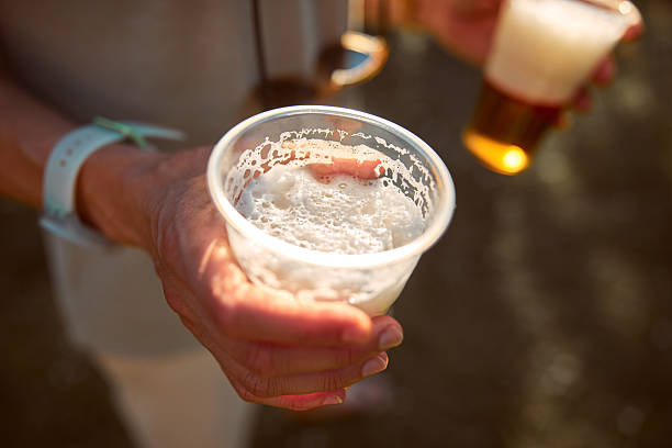 istock Person holding beer cup outdoors on a sunny day. 2243745924