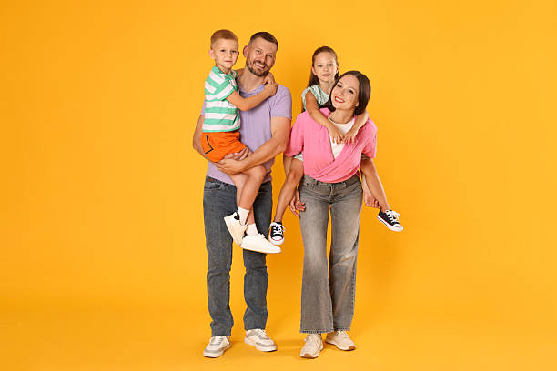 istock Lovely family posing together on yellow background 2243747853