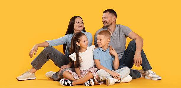 istock Lovely family posing together on yellow background 2243747854