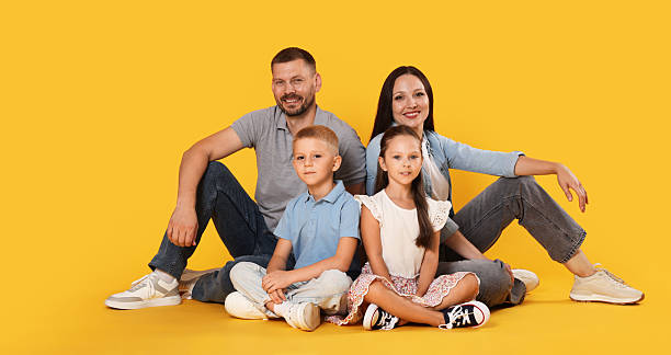 istock Lovely family posing together on yellow background 2243748162