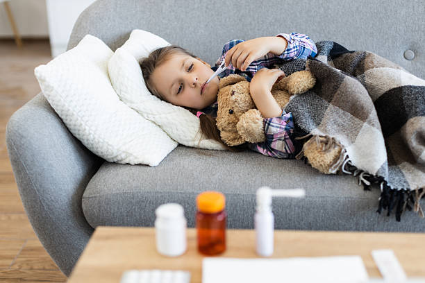 istock Sick child with a fever resting on a couch 2243748862