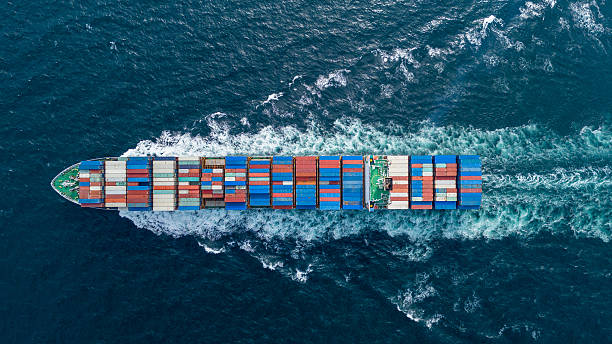 istock Aerial view of container cargo ship sailing through deep blue ocean, leaving waves behind. Perfect for concepts of maritime logistics, global shipping, export-import trade, and sea freight transport. 2243752148