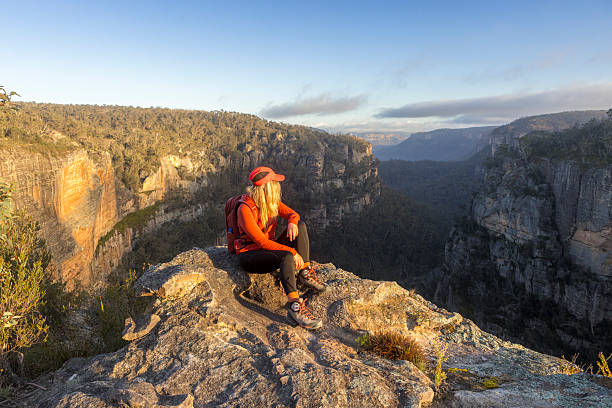 istock Hiker resting on a rock overlooking a canyon with sandstone cliff walls 2243752749