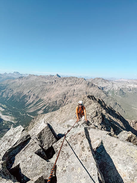 istock Woman Climbing Rocky Mountain Peak with Rope 2243753388
