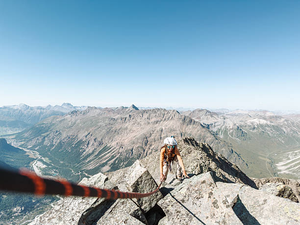 istock Woman Climbing Rocky Mountain Peak with Rope 2243753409