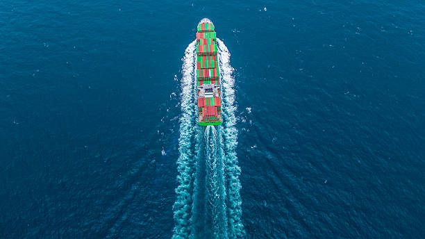 istock Aerial view of container cargo ship sailing through deep blue ocean, leaving waves behind. Perfect for concepts of maritime logistics, global shipping, export-import trade, and sea freight transport. 2243753565